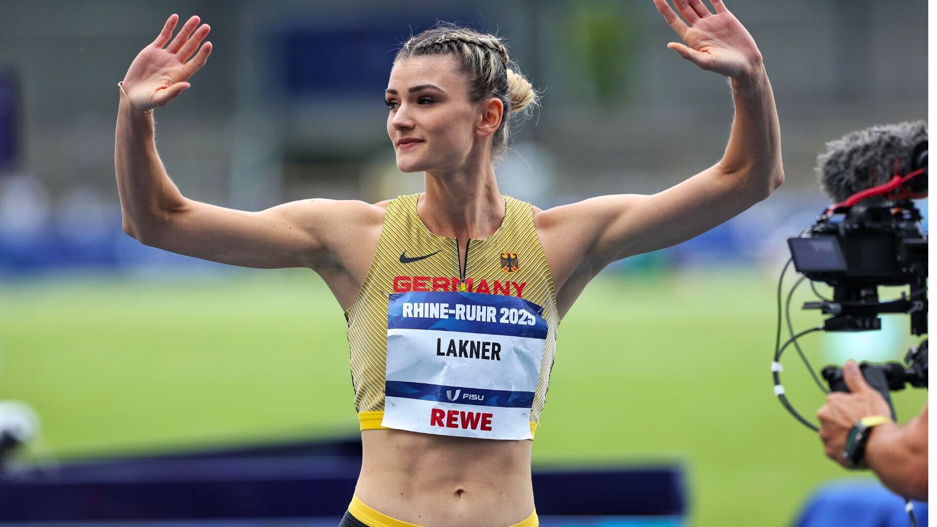 Langsprinterin Jana Lakner winkt mit angehobenen Armen.