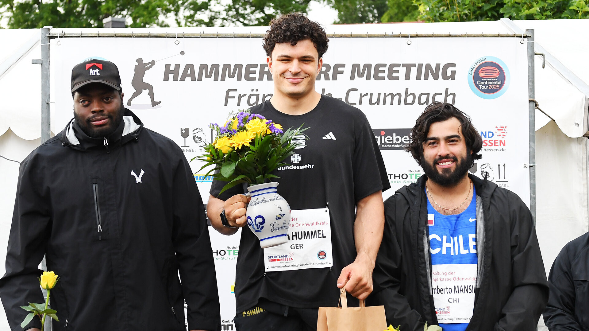 Hammerwerfer Merlin Hummel bei der Siegerehrung in Fränkisch-Crumbach, neben ihm die Zweit- und Drittplatzierten Denzel Comenentia und Humberto Mansilla