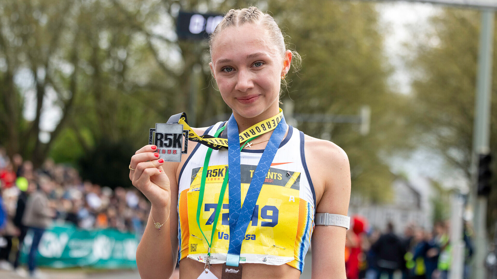 Vanessa Mikitenko zeigt ihre Medaille vom R5K-Sieg