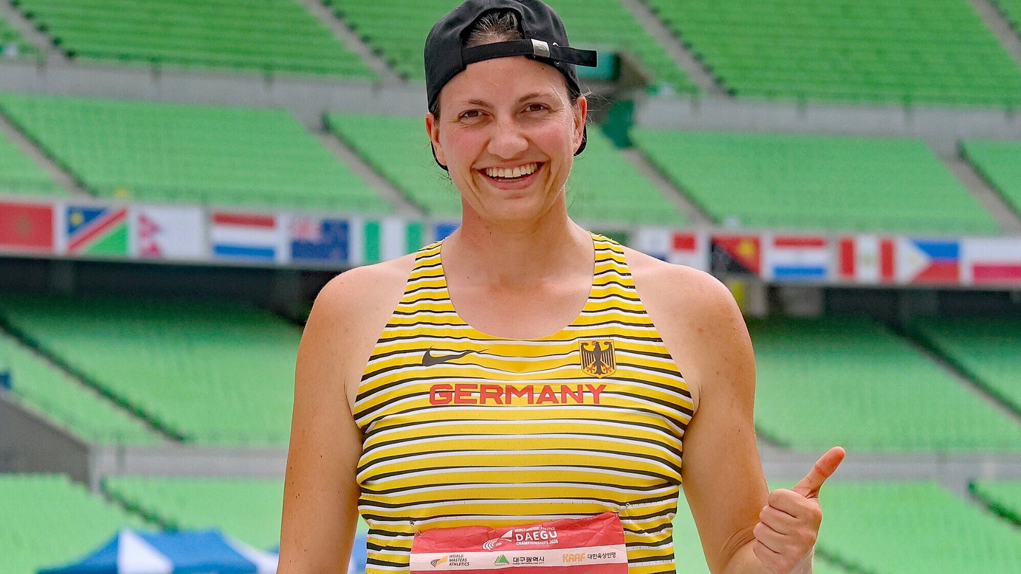 Ein Porträt der deutschen Masters-Leichtathletin Sandra Büttner, die den linken Daumen nach oben zeigt.