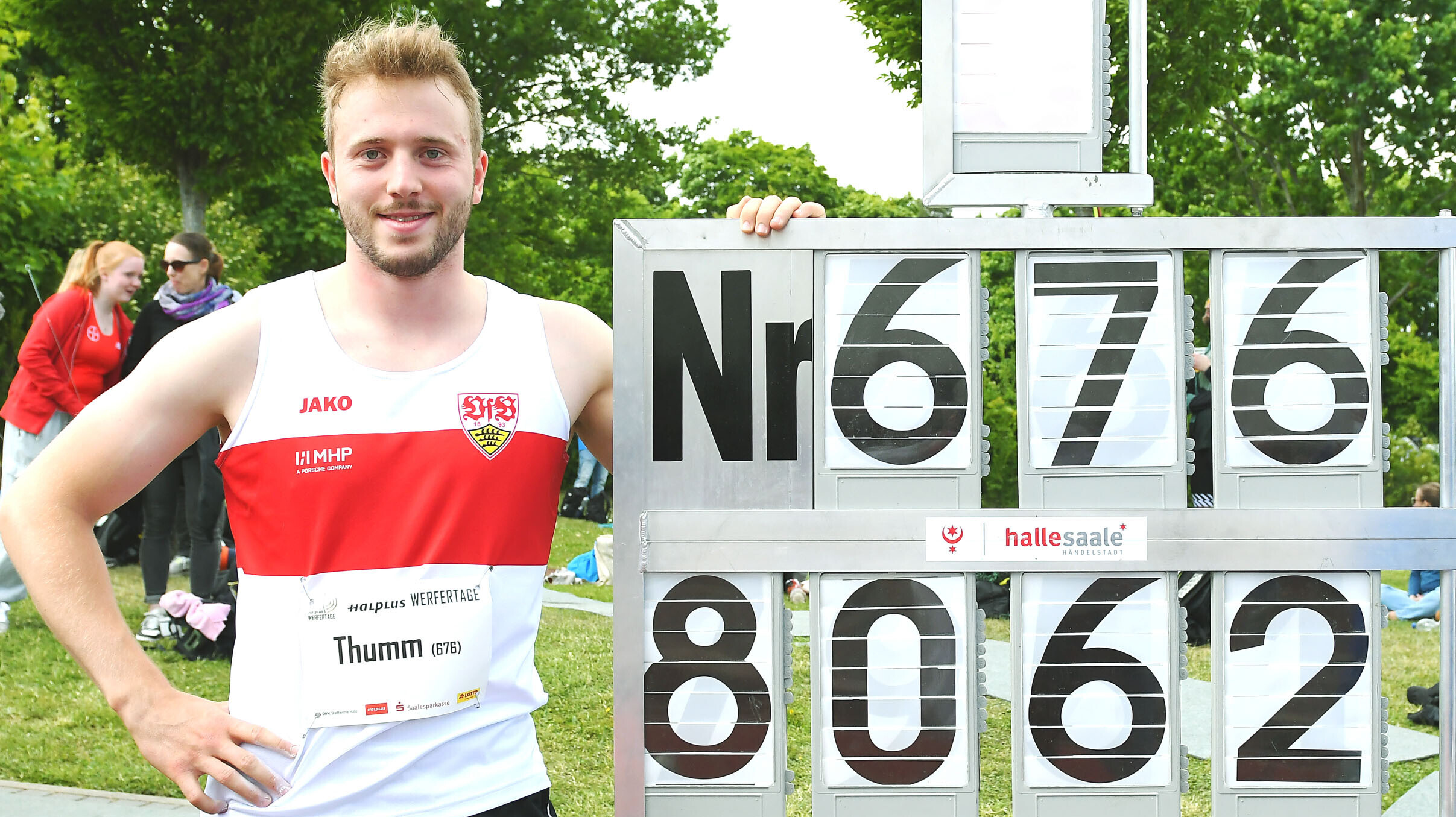 Speerwerfer Nick Thumm, im Trikot des VfB Stuttgart, posiert neben einer Anzeigetafel, auf der seine Weite 80,62 Meter notiert ist. 