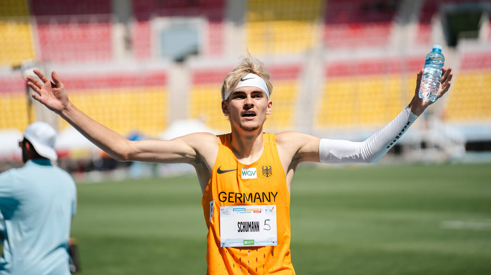 Andor Schumann jubelt mit erhobenen Armen und einer Wasserflasche in der Hand. 