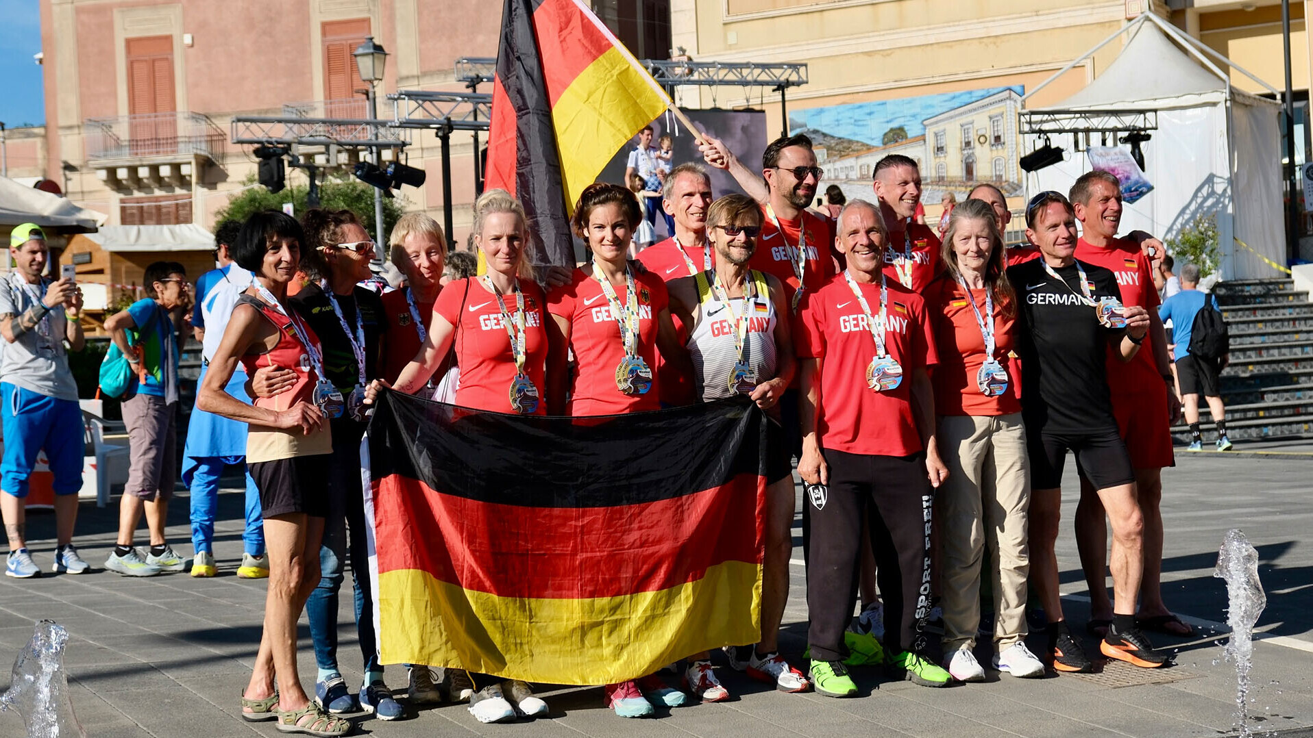 Mannschaftsfoto der deutschen Masters mit Deutschlandfahnen bei der Berglauf-EM. 