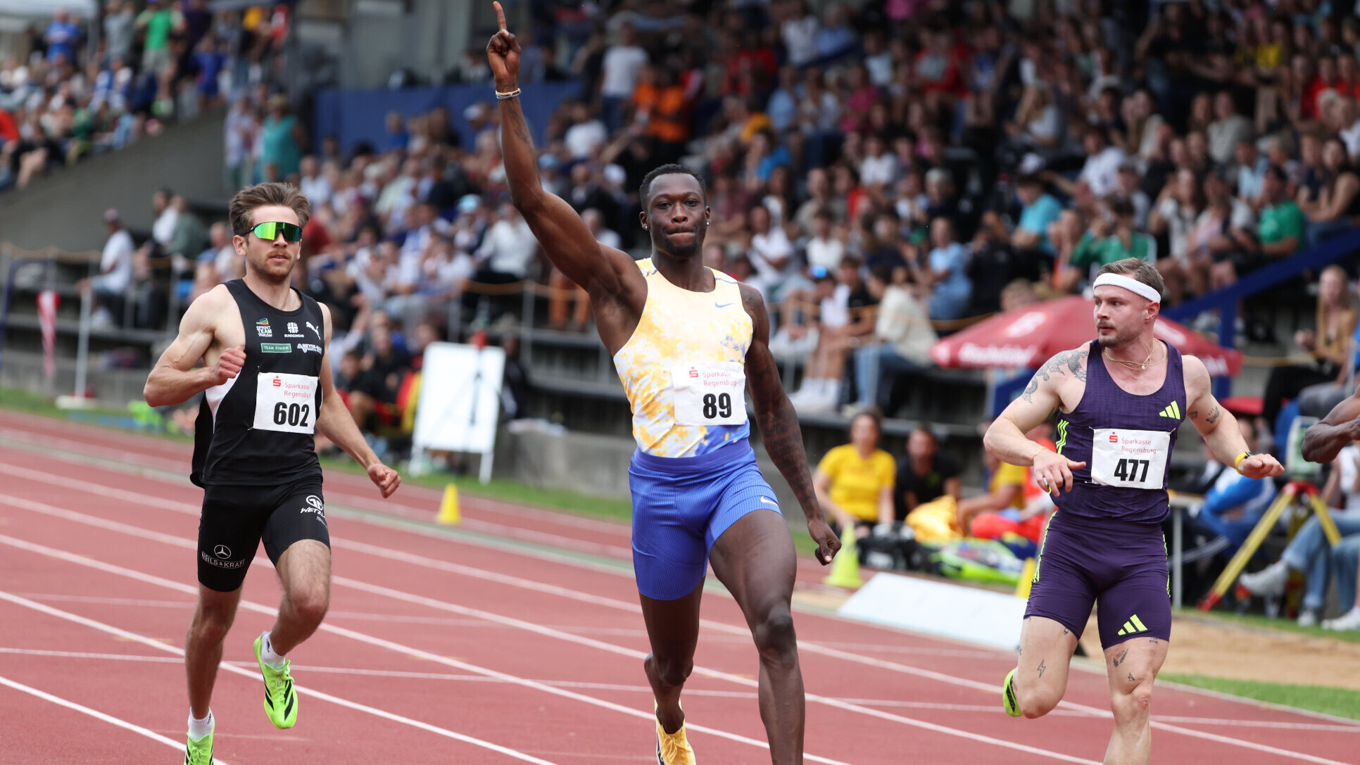 Der deutsche Sprinter Owen Ansah läuft mit nach oben gestrecktem rechten Arm ins Ziel.