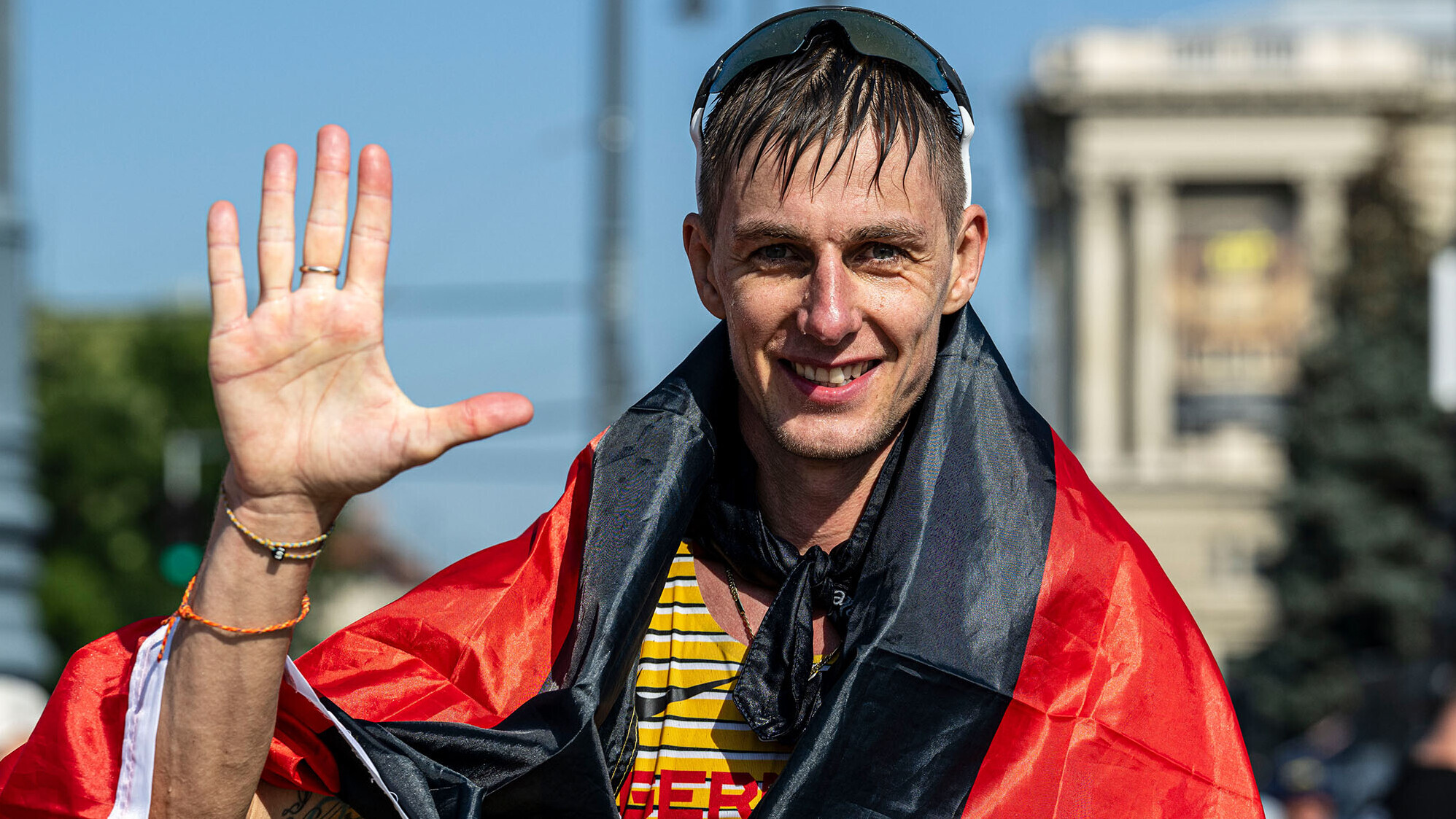 Geher Christopher Linke mit Deutschland-Fahne um die Schultern und hochgereckter Hand
