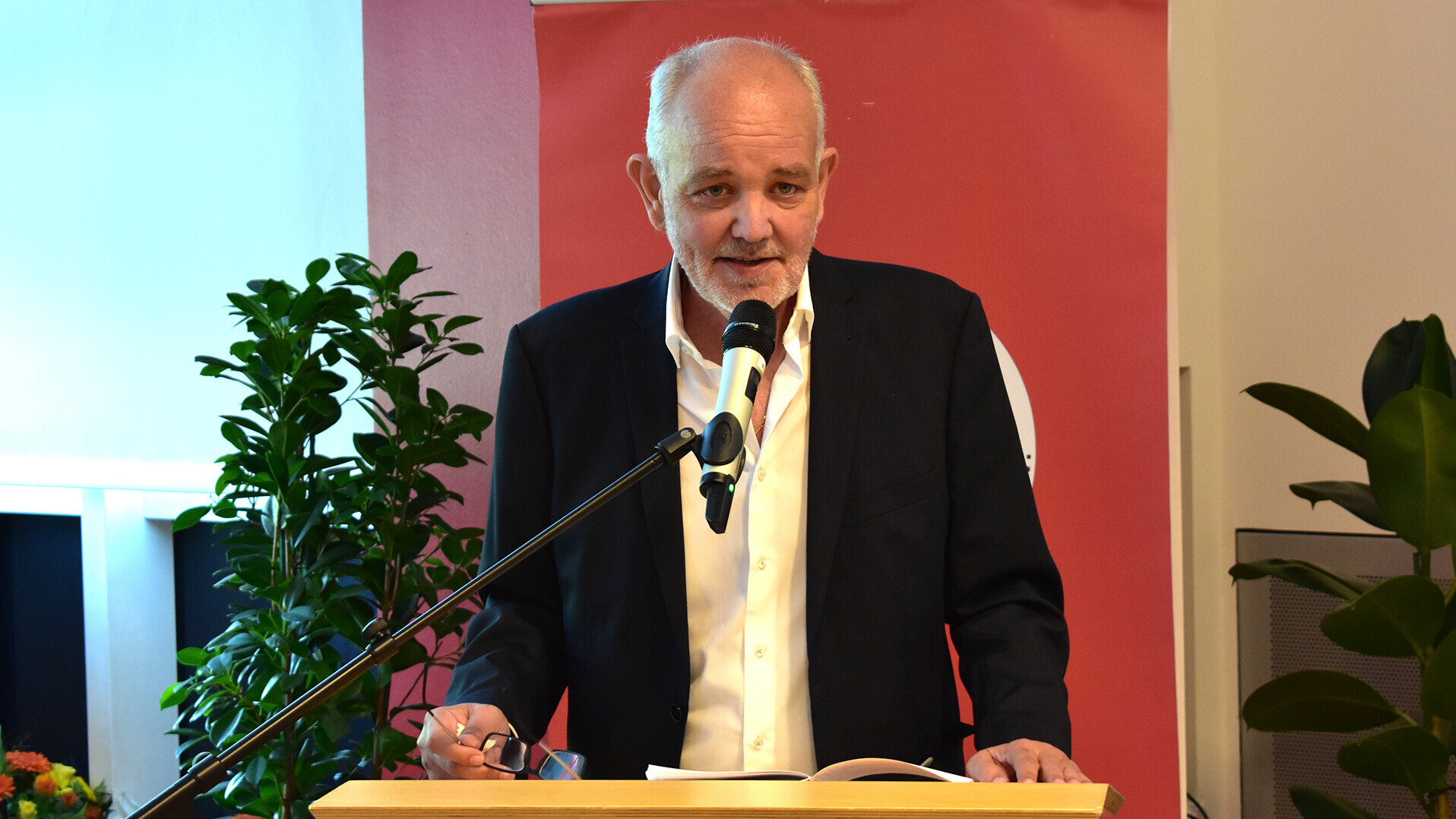 Der scheidende Präsident Wolfgang Müller-Kallweit steht bei der Mitgliederversammlung mit einem Mikrofon am Rednerpult.
