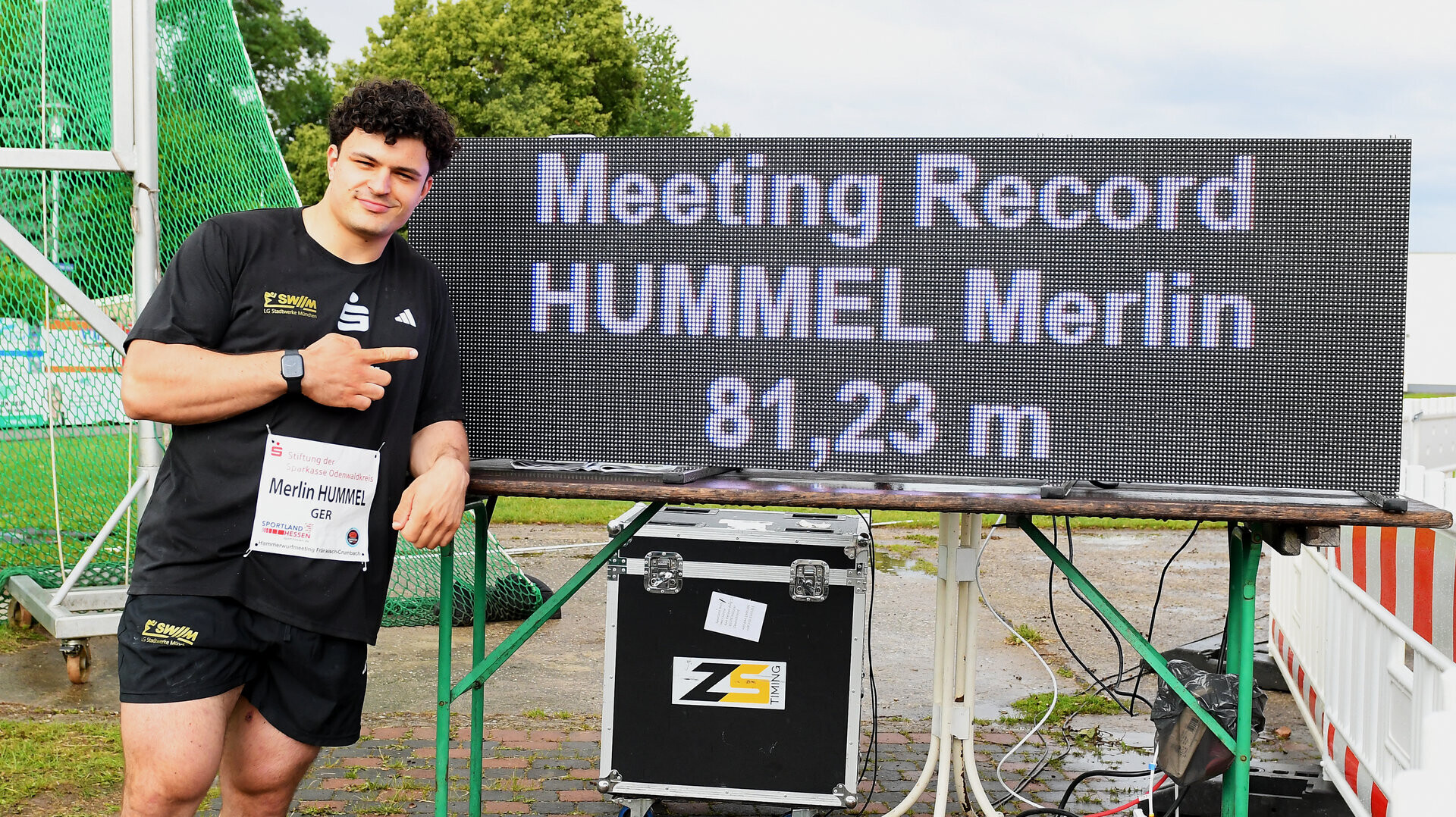 Hammerwerfer Merlin Hummel neben einer Anzeigetafel, die seine Weite von 81,23 Metern zeigt