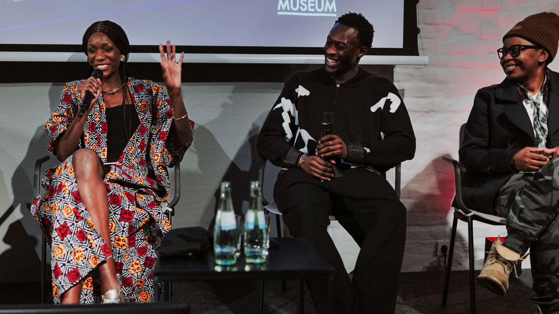 Liz Shoo,  Owen Ansah und Shary Reeves sitzen auf einem Podium und unterhalten sich.