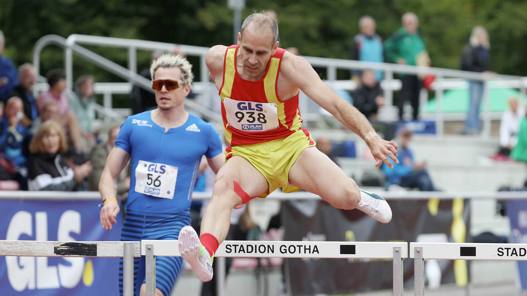 Matti Herrmann im rotgelben Trikot beim Überqueren einer Hürde