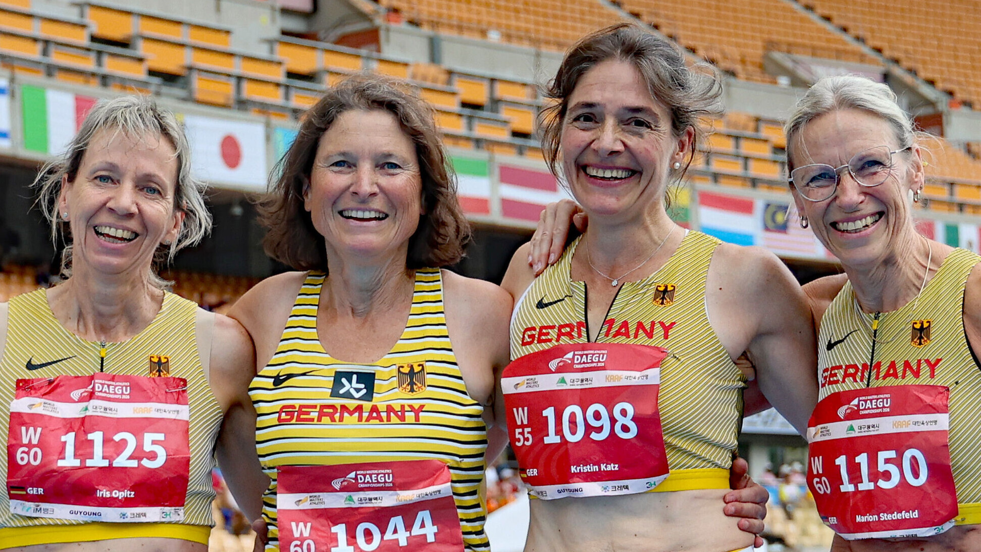 Vier Masters-Athletinnen im Deutschlandtrikot lächeln Arm in Arm in die Kamera.
