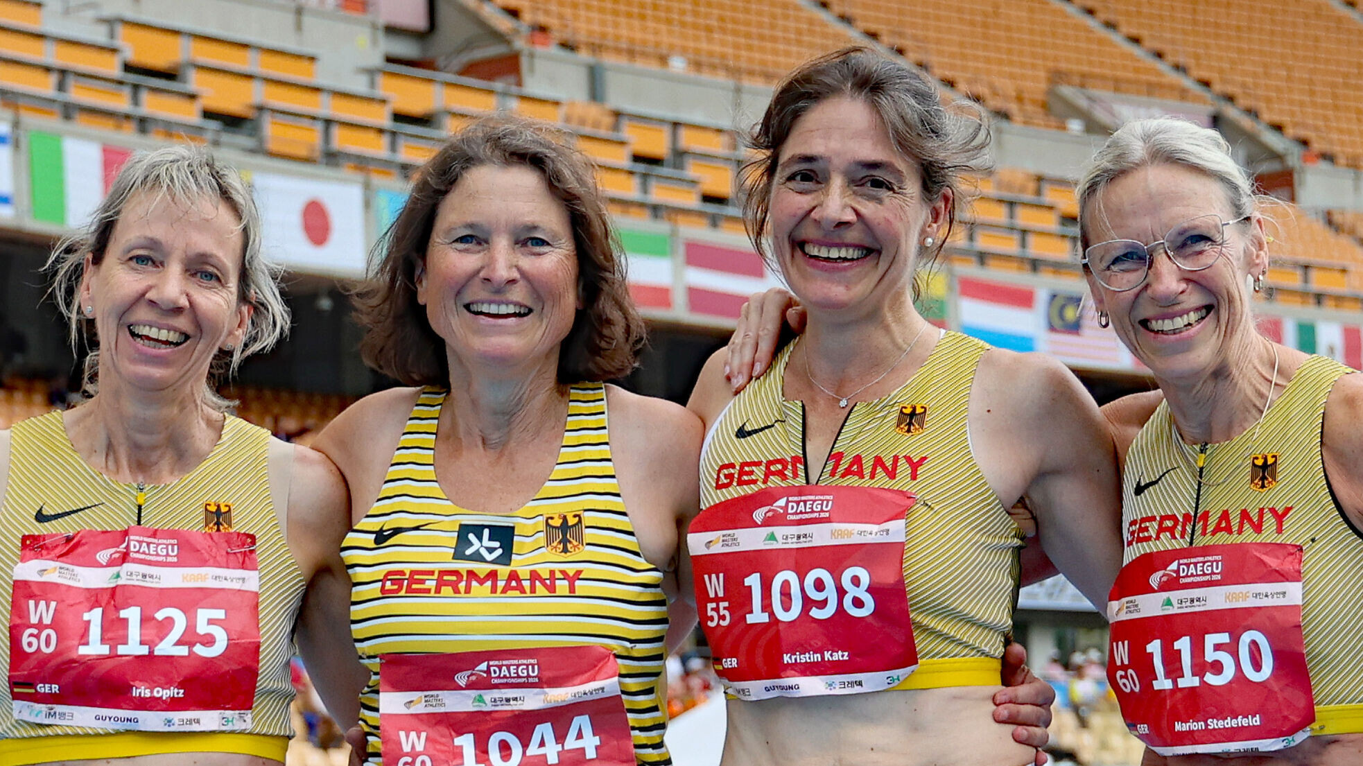 Vier Masters-Athletinnen im Deutschlandtrikot lächeln Arm in Arm in die Kamera.
