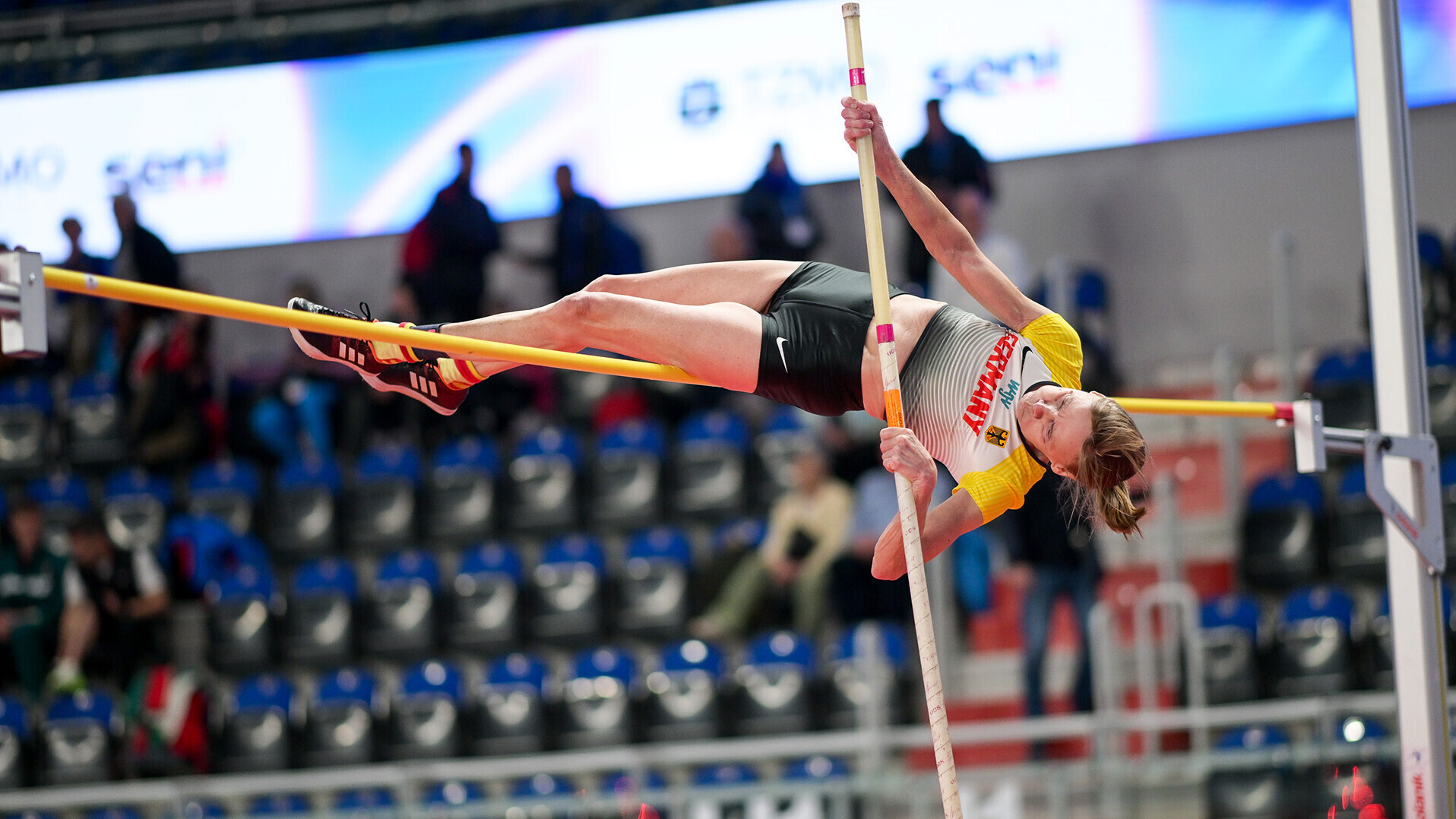 Petra Herrmann katapultiert sich aufgerollt am Stab über die Latte