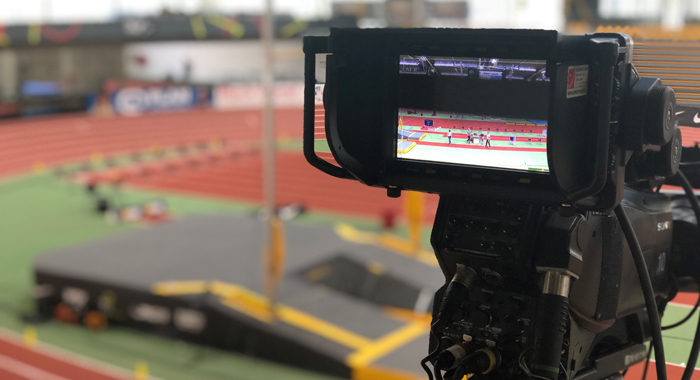 Kamera-Bildschirm gerichtet auf Leichtathletik-Halle mit Rundbahn und Stabhochsprung-Anlage im Hintergrund