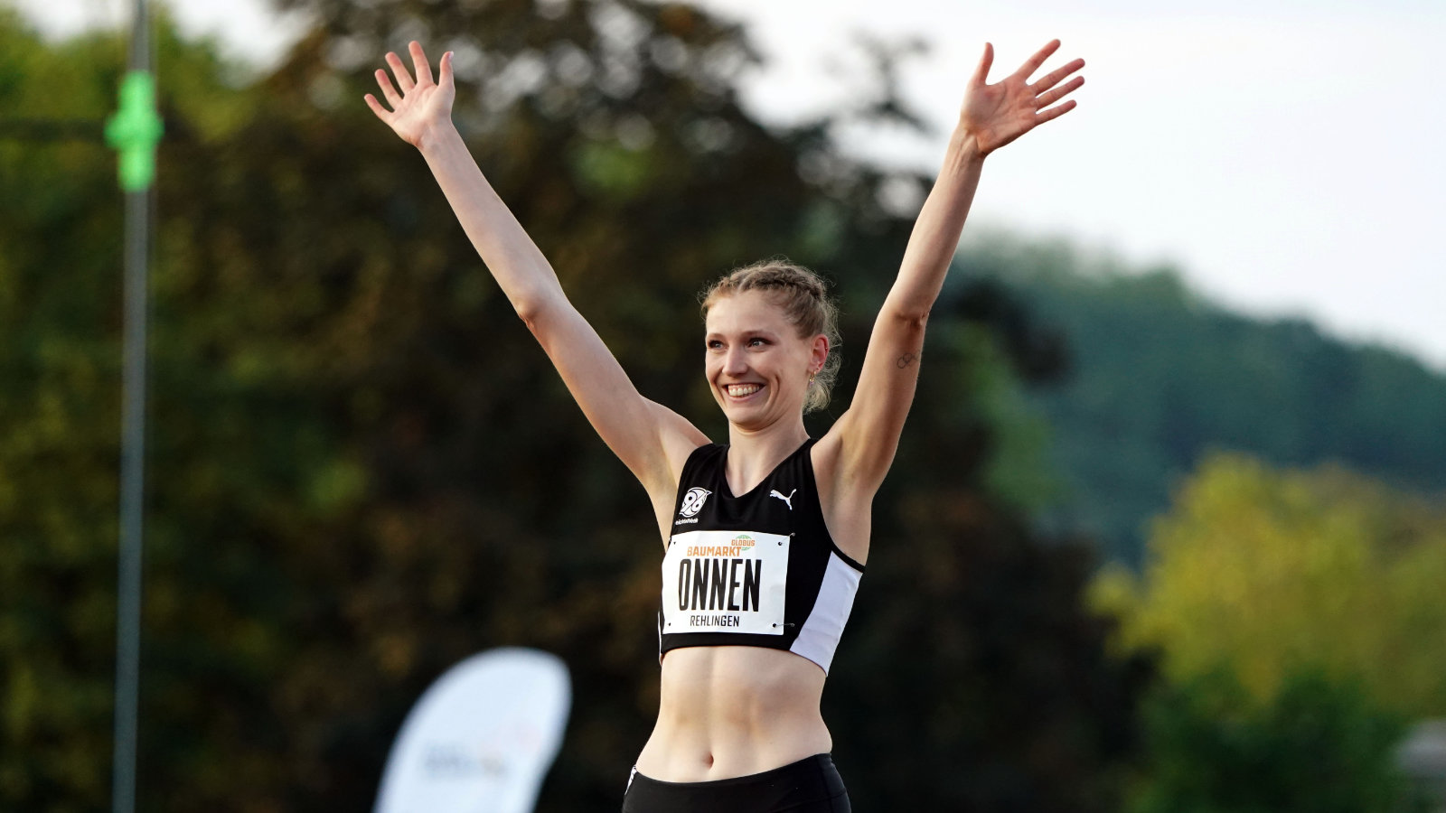 Hochspringerin Imke Onnen winkt im Wettkampf-Dress den Zuschauern zu
