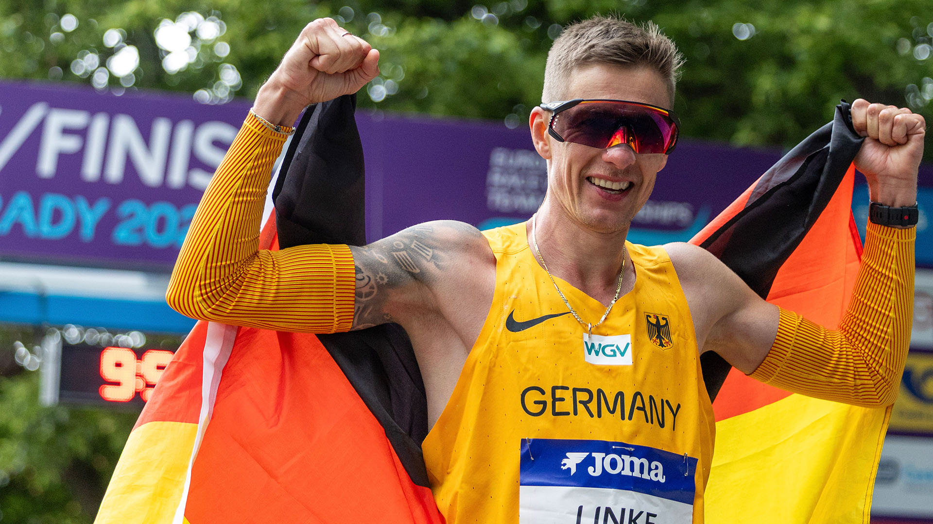 Christopher Linke jubelt mit Deutschlandfahne in der Hand bei der Team-EM der Geher